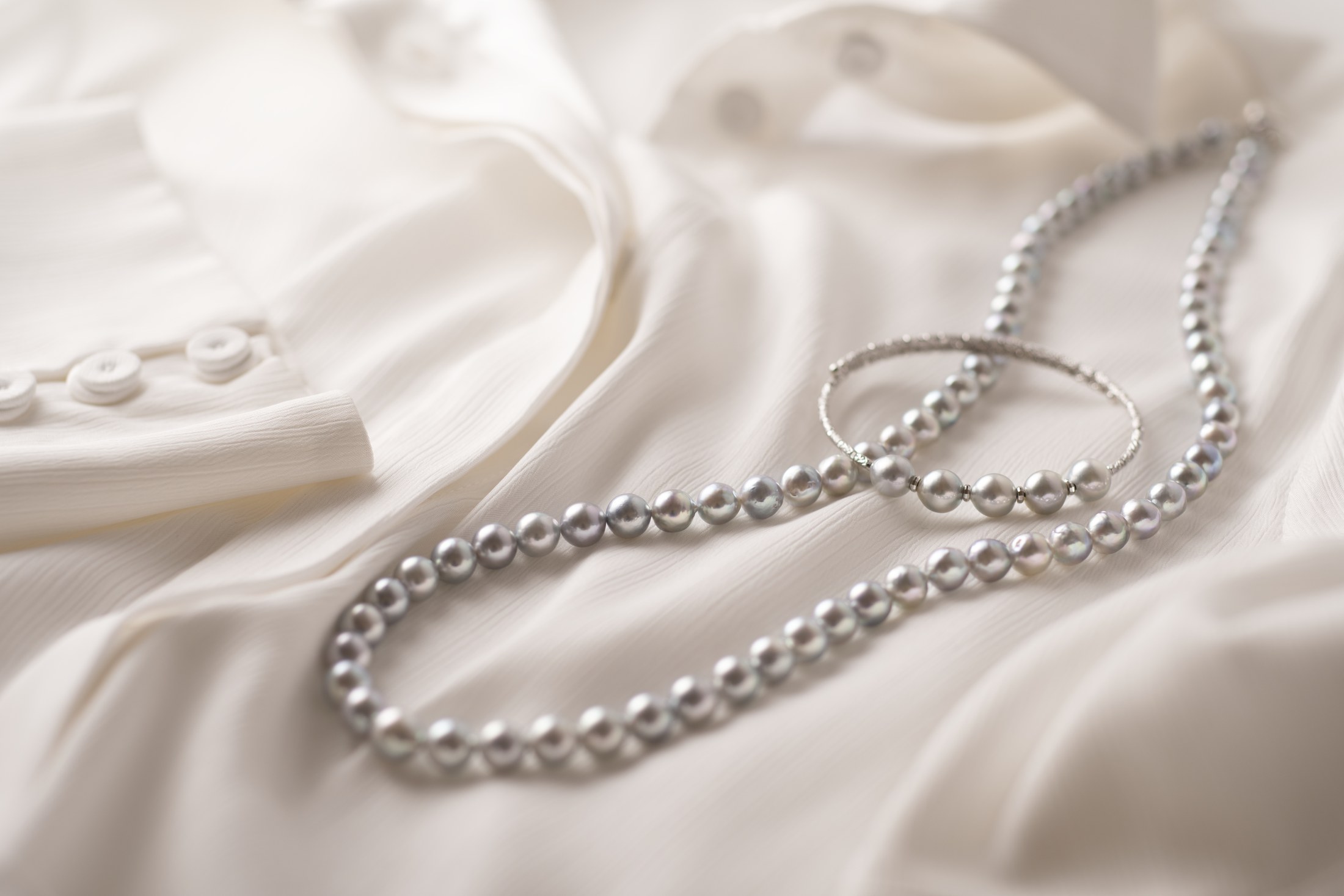 Pearl necklace arranged on satin fabric