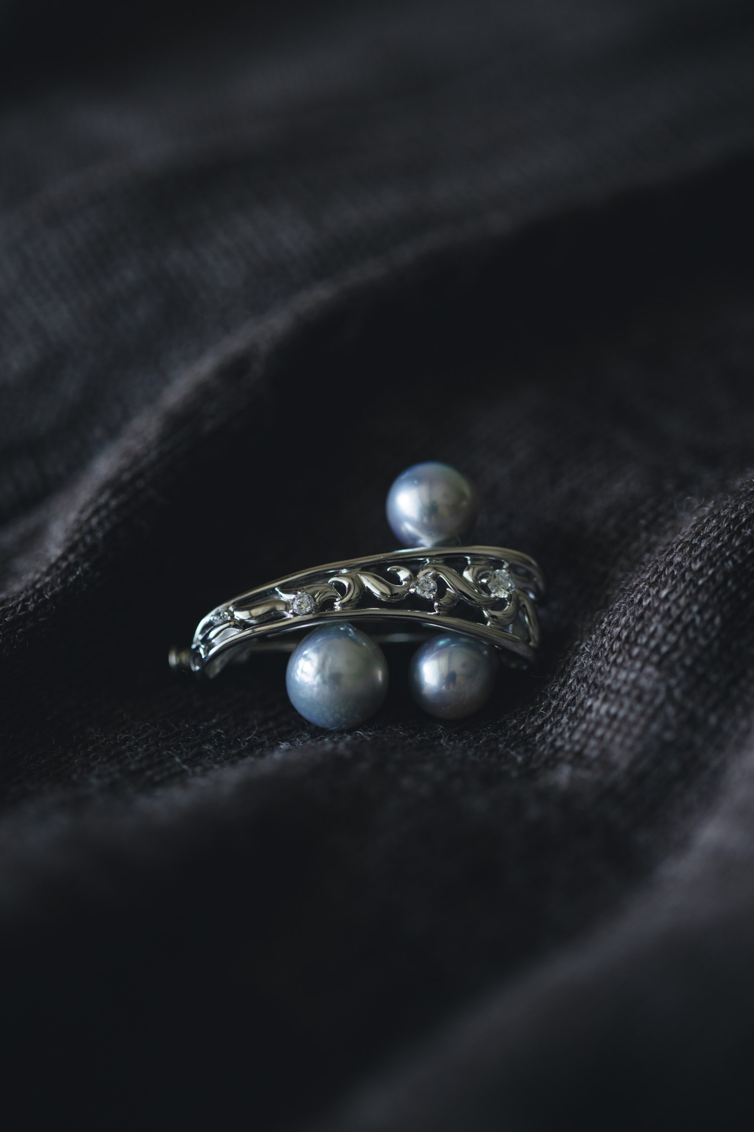 Bis SPIRA gray pearl brooch on dark fabric