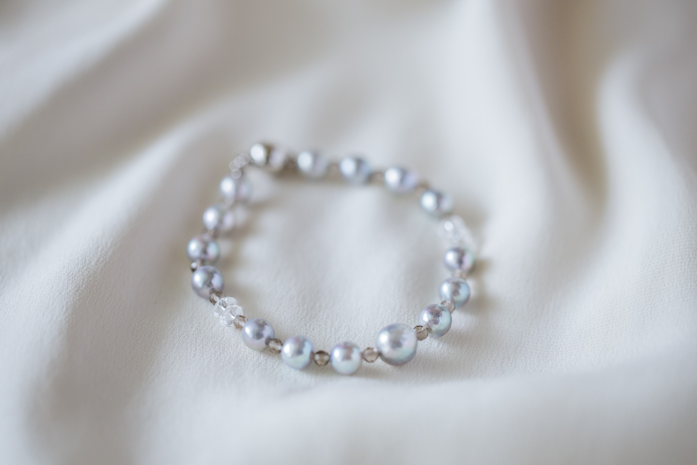 Gray Akoya pearl and smoky quartz bracelet on white fabric