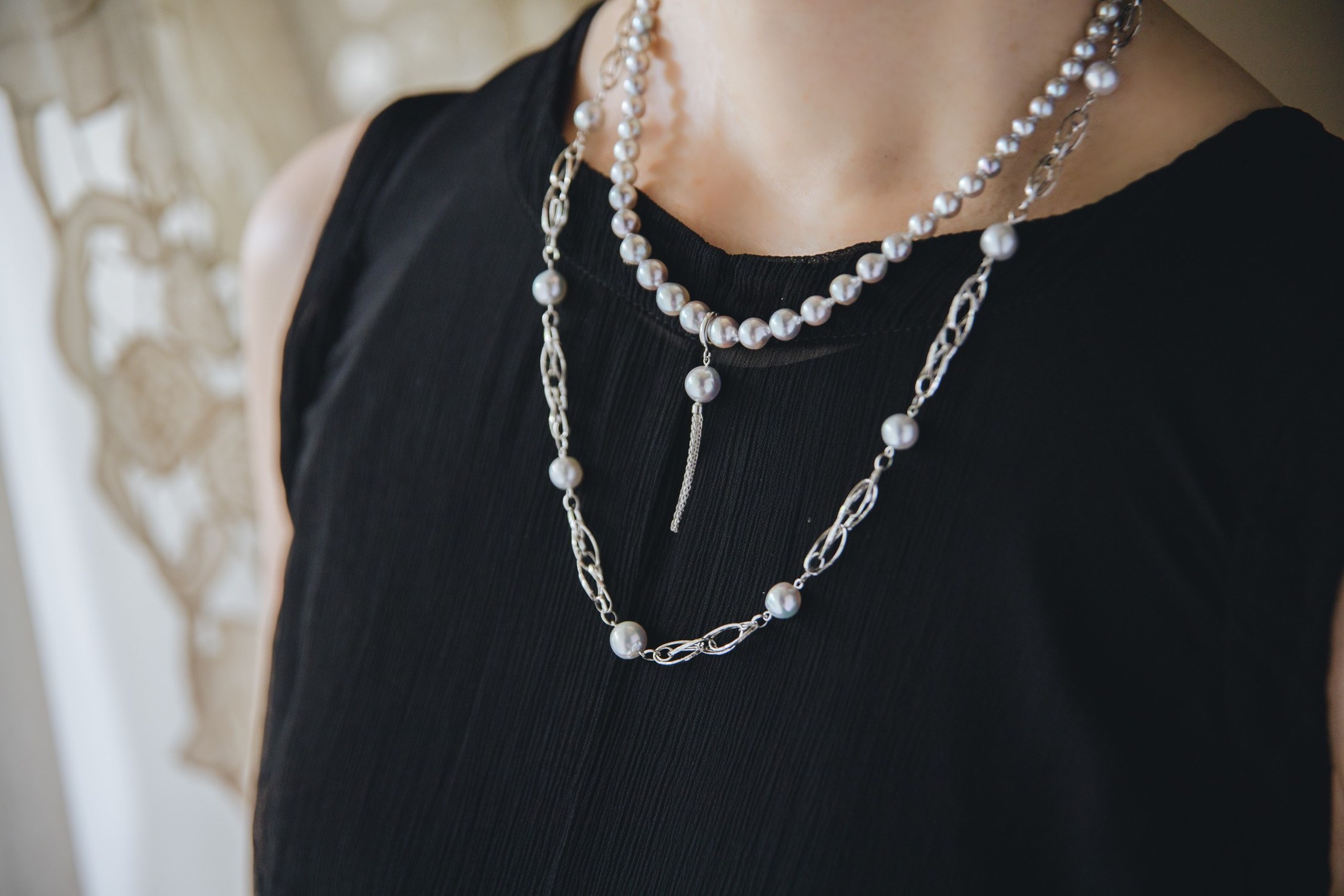 IRIS SPIRA gray Akoya pearl necklace worn with a black dress