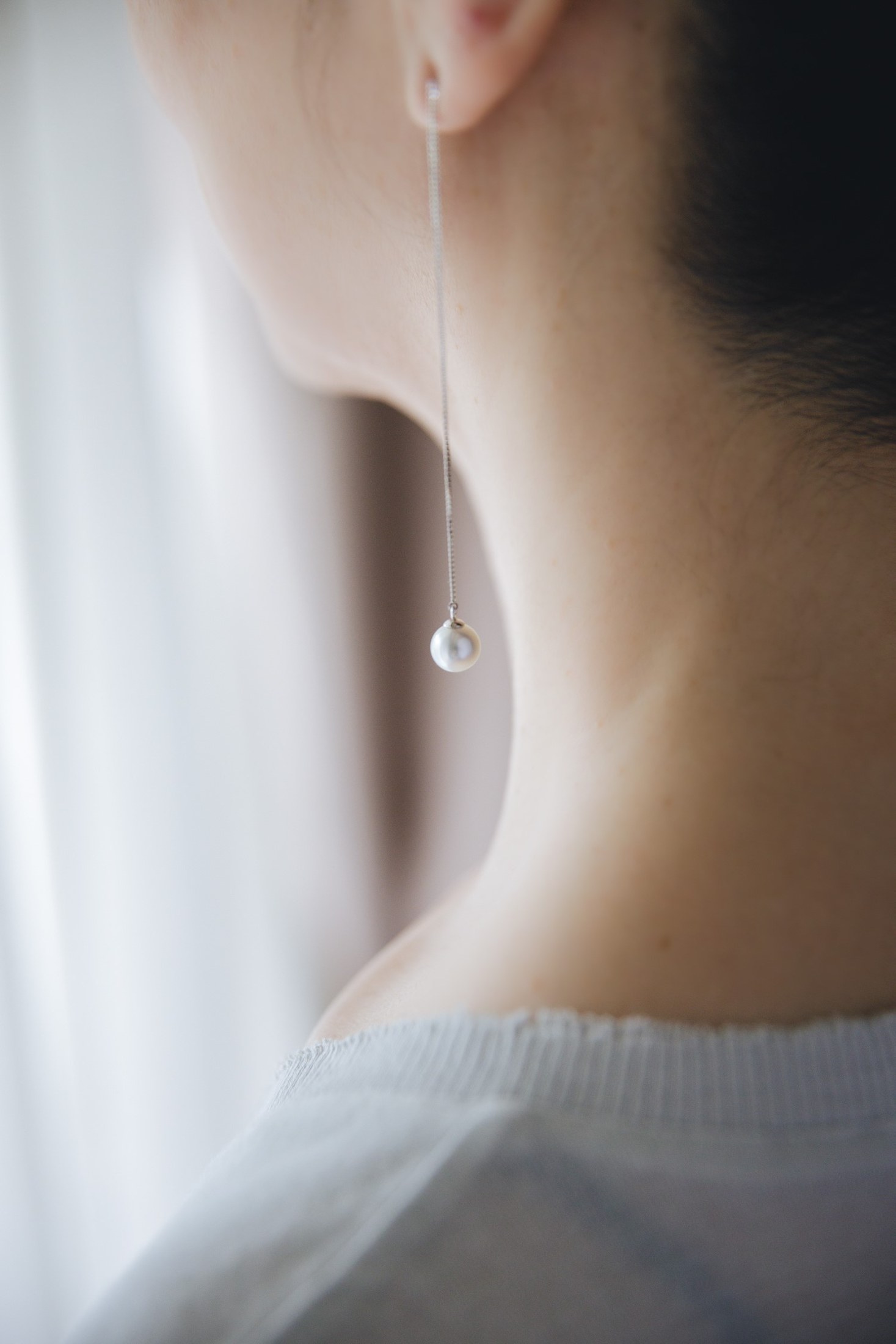 Pearl drop earring worn at the ear