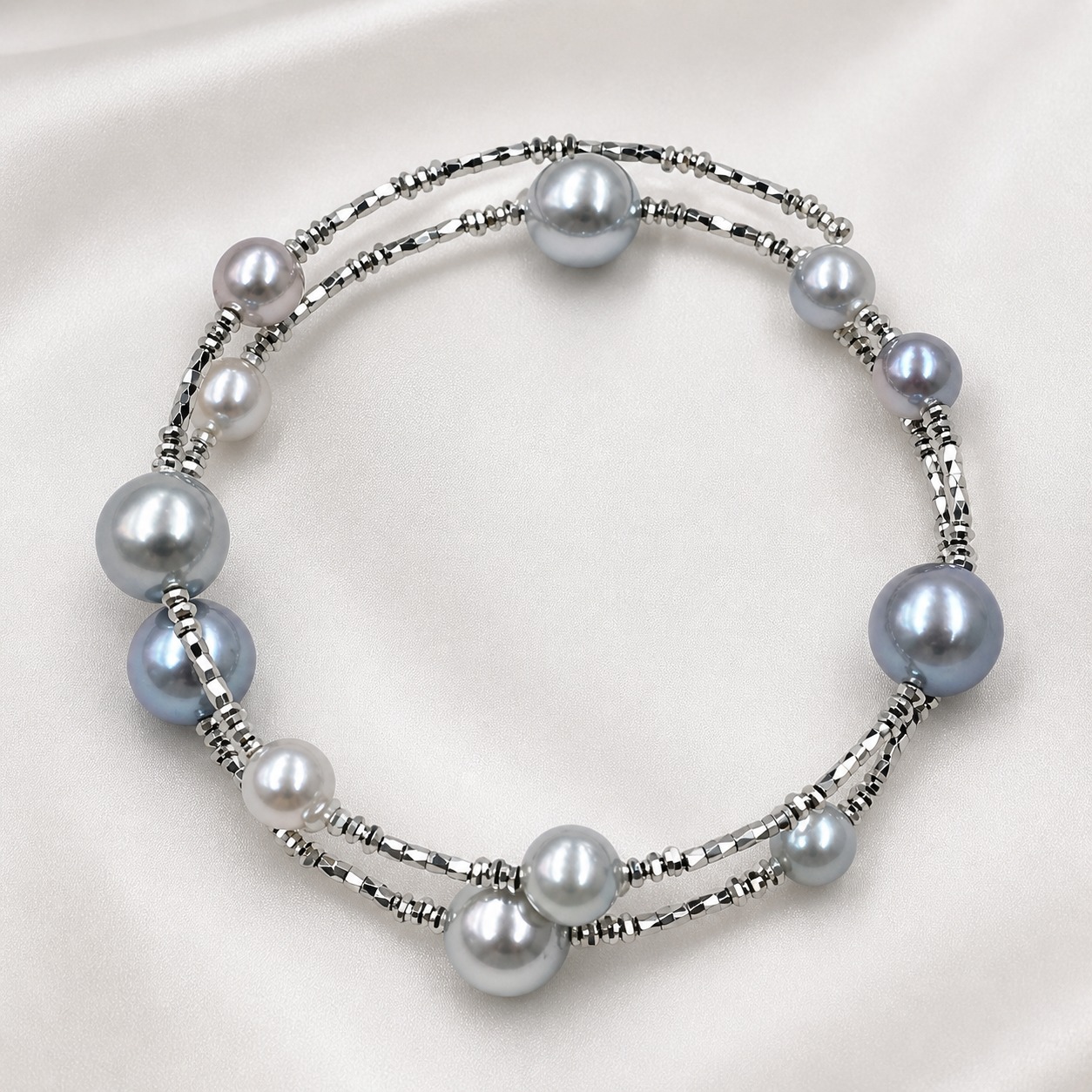 Gray pearl bracelet with silver beads on pale satin